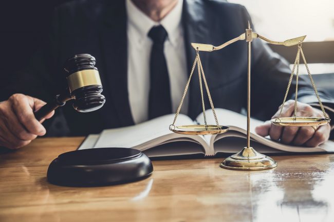 Male lawyer or judge working with contract papers, Law books and