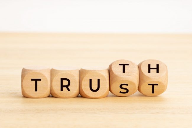Truth or trust concept. Text on wooden blocks. White background. Copy space