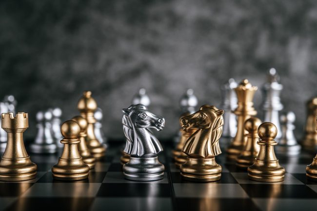 Gold and Silver Chess on chess board game for business metaphor