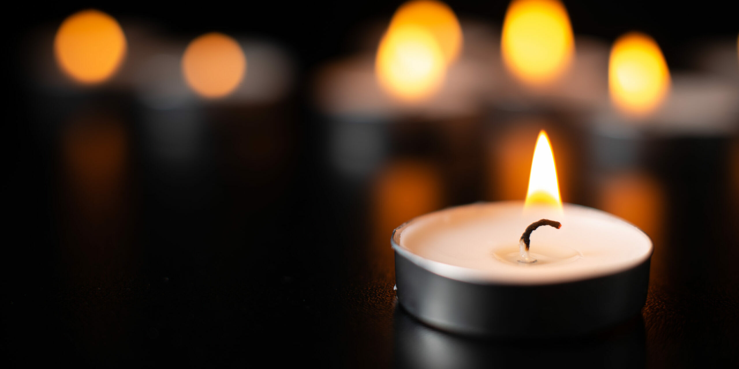 front-view-burning-candles-pitch-black-surface