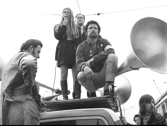 A woman addresses protestors, with Jim Cairns and George Coote, at the Vietnam War Moratorium Day, Melbourne, May 1970; picture by Tim Aickin; Trove, National Library of Australia, PIC Online access #PIC/14404/2.