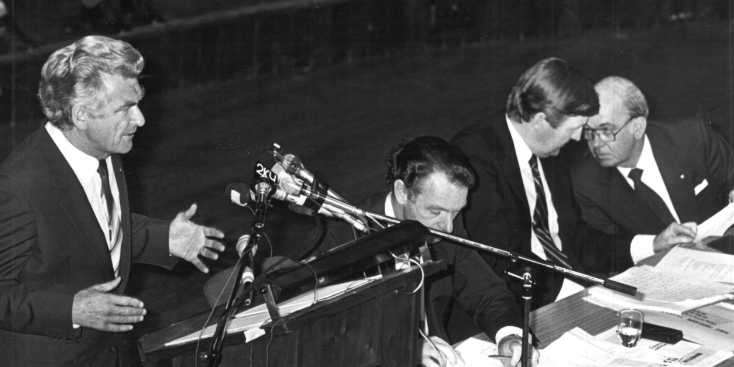 Prime Minister Bob Hawke speaking at the Labor Council of NSW Annual General Meeting, 1984, at the Sydney Town Hall.  On the stage (seated) are from left to right, John MacBean (Assistant Secretary), Barrie Unsworth (Secretary), and Jim Gibson (President).  Photo: from Michael Easson papers, Noel Butlin Archives, Menzies Library, Australian National University.  (Photo not published with article). Prime Minister Bob Hawke speaking at the Labor Council of NSW Annual General Meeting, 1984, at the Sydney Town Hall. On the stage (seated) are from left to right, John MacBean (Assistant Secretary), Barrie Unsworth (Secretary), and Jim Gibson (President). Photo: from Michael Easson papers, Noel Butlin Archives, Menzies Library, Australian National University. (Photo not published with article).