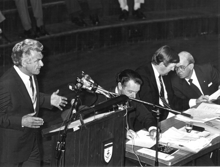 Prime Minister Bob Hawke speaking at the Labor Council of NSW Annual General Meeting, 1984, at the Sydney Town Hall. On the stage (seated) are from left to right, John MacBean (Assistant Secretary), Barrie Unsworth (Secretary), and Jim Gibson (President). Photo: from Michael Easson papers, Noel Butlin Archives, Menzies Library, Australian National University. (Photo not published with article).